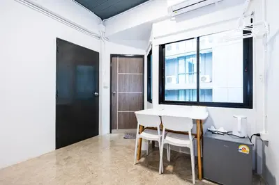 a white table and chairs in a room with a window at xx Yellow Place Sukhumvit Soi 2 -เยลโล เพลส สุขุมวิทซอย 2 in Bangkok