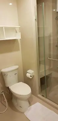 a bathroom with a toilet and a glass shower at Mari's space Riverview in Nonthaburi