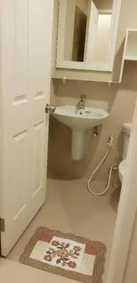 a bathroom with a sink and a toilet and a mirror at Mari's space Riverview in Nonthaburi