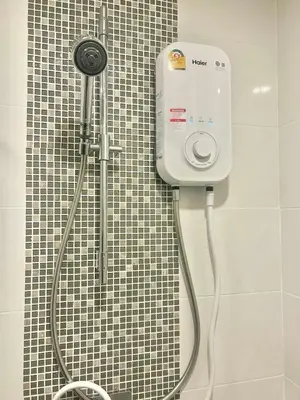 a shower in a bathroom with a black and white tile wall at Metro luxe riverfront resort style condo in Ban Sai Ma