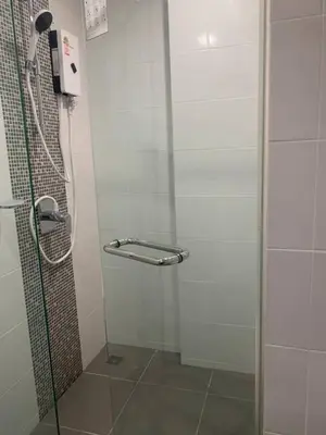 a shower with a glass door in a bathroom at Metro luxe riverfront resort style condo in Ban Sai Ma