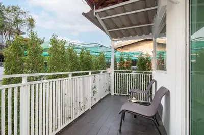 a balcony with two chairs and a table at Designer house Chao Phraya River - OH Homes 12 in Bangkok