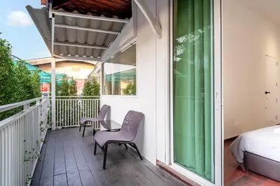 a balcony with a bed and two chairs and a table at Designer house Chao Phraya River - OH Homes 12 in Bangkok