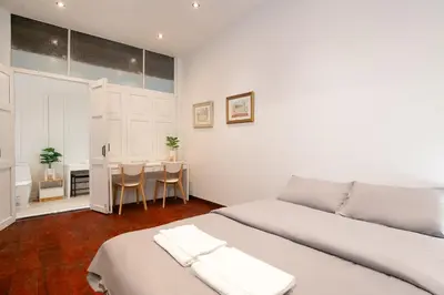 a white bedroom with two beds and a table at Designer house Chao Phraya River - OH Homes 12 in Bangkok