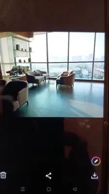 a living room with couches and a room with windows at IDEO Wat Thaphra Bangkok Yai in Bangkok