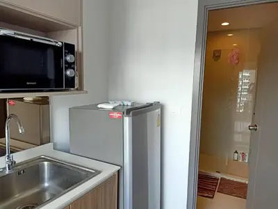 a kitchen with a stainless steel refrigerator and a sink at IDEO Wat Thaphra Bangkok Yai in Bangkok