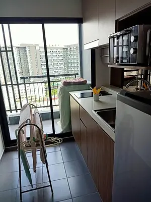 a kitchen with a view of a building from a window at IDEO Wat Thaphra Bangkok Yai in Bangkok