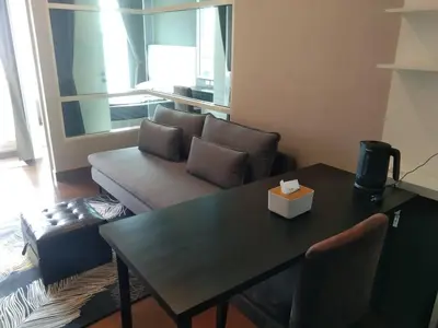 a living room with a table and a couch at Modern Place Watthana, Thonglor BTS, Sukhumvit in Bangkok