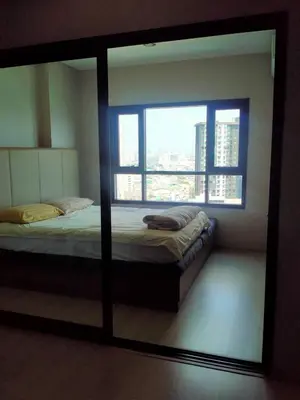 a mirror reflecting a bed in a room with a window at Cyber carer NSW in Bangkok Yai