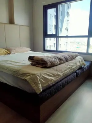 a bed in a bedroom with a large window at Cyber carer NSW in Bangkok Yai