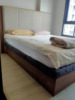 a bed with a wooden bed frame in a bedroom at Cyber carer NSW in Bangkok Yai