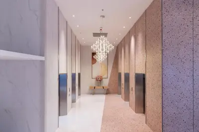 a hallway with a chandelier and a long corridor at Queensland Hotel Bangkok in Bangkok