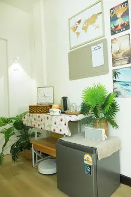 a kitchen with a table and a refrigerator at Enjoyo Getaway in Bangkok