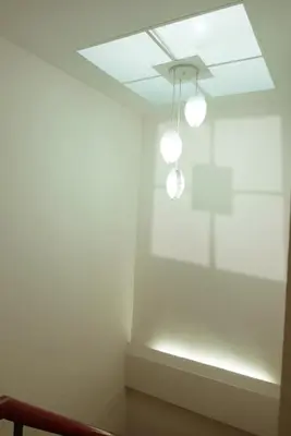 a room with white walls and a ceiling with lights at Enjoyo Getaway in Bangkok