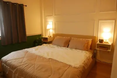 a bedroom with a white bed with two lamps at Enjoyo Getaway in Bangkok
