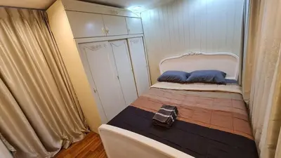 a small bedroom with a bed with blue pillows at 1Br HiSpeed Net, Low rise condo, Near BTS Ekamai in Khlong Toei