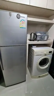 a kitchen with a refrigerator and a washing machine at 1Br HiSpeed Net, Low rise condo, Near BTS Ekamai in Khlong Toei