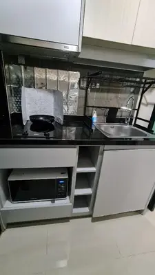 a kitchen counter with a sink and a microwave at 1Br HiSpeed Net, Low rise condo, Near BTS Ekamai in Khlong Toei