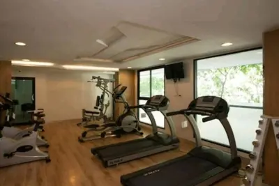 a gym with several treadmills and elliptical machines at 1Br HiSpeed Net, Low rise condo, Near BTS Ekamai in Khlong Toei