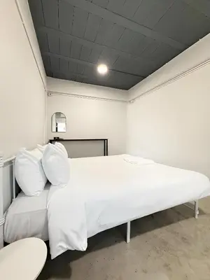 a white bed in a room with a ceiling at xx Yellow Place Sukhumvit 2 - BTS Nana Pro in Bangkok