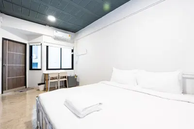 a bedroom with a large white bed and a table at xx Yellow Place Sukhumvit 2 - BTS Nana Pro in Bangkok