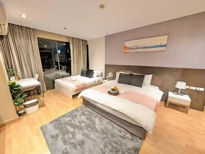 a bedroom with a large bed and a living room at Spacious and Renovated 1-Bedroom 100m to Nana BTS - 55 sqm in Bangkok