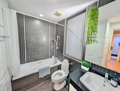 a bathroom with a tub and a toilet and a sink at Spacious and Renovated 1-Bedroom 100m to Nana BTS - 55 sqm in Bangkok