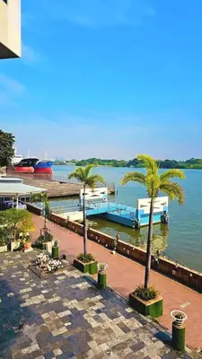 a marina with palm trees and a dock with a boat at River View 03 in Bangkok
