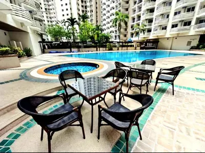 a patio with tables and chairs next to a swimming pool at River View 03 in Bangkok