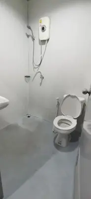 a white bathroom with a toilet and a sink at XX GO INN Khaosan ถนนข้าวสาร in Bangkok