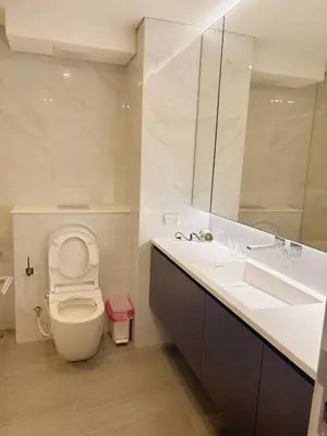a bathroom with a toilet and a sink and a mirror at Cassia Rama9 Loft Highrise View Central in Bangkok