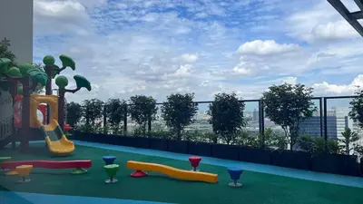 a balcony with a playground with a view of a city at Cassia Rama9 Loft Highrise View Central in Bangkok