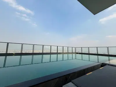a balcony with a swimming pool on top of a building at Cassia Rama9 Loft Highrise View Central in Bangkok
