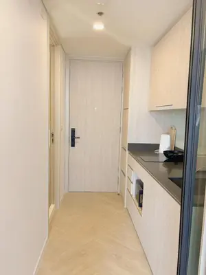 a hallway of a kitchen with a door in it at Cassia Rama9 Loft Highrise View Central in Bangkok