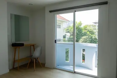 a room with a sliding glass door leading to a balcony at Baan Khun Pra No 1 Bangkok Duplex in Bangkok