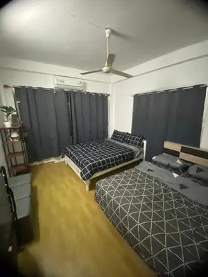 a bedroom with two beds and a ceiling fan at Sleep Break Hostel Sathon in Bangkok