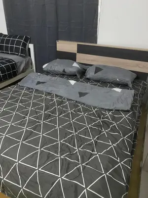 a bedroom with a bed with a black and white comforter at Sleep Break Hostel Sathon in Bangkok
