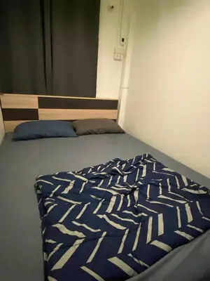 a bed in the corner of a room at Sleep Break Hostel Sathon in Bangkok