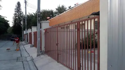 a person with a broom standing next to a fence at บ้านเช่าดีๆเงียบสงบที่ลงตัว in Ban Lat Tanot
