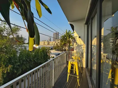 a yellow stool on a balcony with a view of the city at Siri Designer 3-Storey Townhouse with Garden and Luxury Amenities in Bangkok