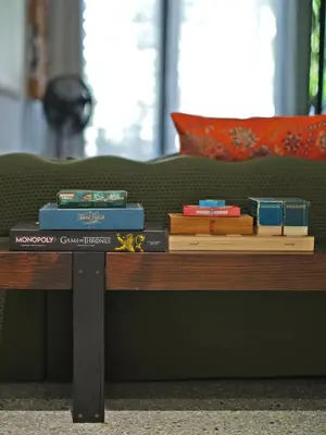 a table with books on it next to a bed at Siri Designer 3-Storey Townhouse with Garden and Luxury Amenities in Bangkok