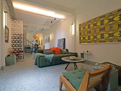 a living room with a green couch and a table at Siri Designer 3-Storey Townhouse with Garden and Luxury Amenities in Bangkok