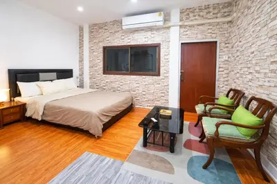 a bedroom with a bed and a brick wall at Sukhumvit 81 Haven House- BTS Onnut in Bangkok