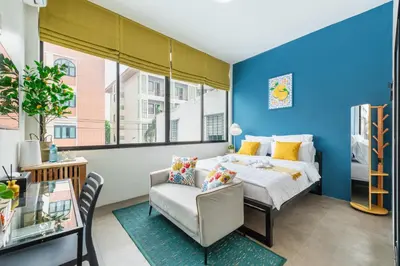 a bedroom with a bed and a chair at Lachata - Hua Mak in Bangkok