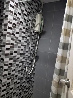 a shower in a bathroom with black and white tiles at MRT SaiMa D condo monthly rent in Ban Sai Ma