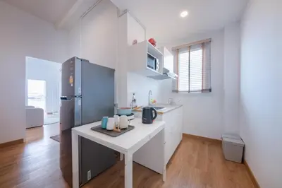 a kitchen with a white counter and a refrigerator at Marshmallow House in Sathani Lak Si