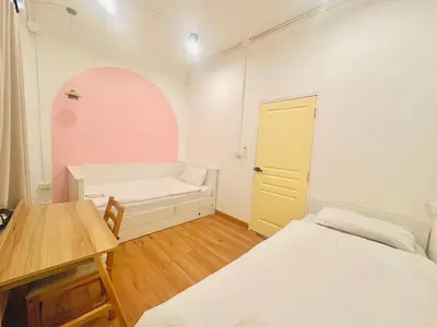 a room with two beds and a desk and a table at Marshmallow House in Sathani Lak Si