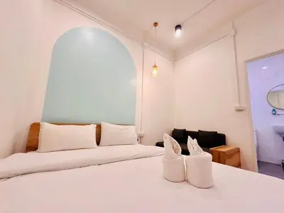 a bedroom with two beds and a large window at Marshmallow House in Sathani Lak Si