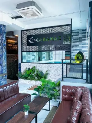 a lobby with a couch and a table and a sign at Cabanaz Pool Villa in Ban Zong Katiam