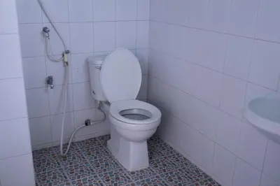 a bathroom with a white toilet and a sink at Cabanaz Pool Villa in Ban Zong Katiam